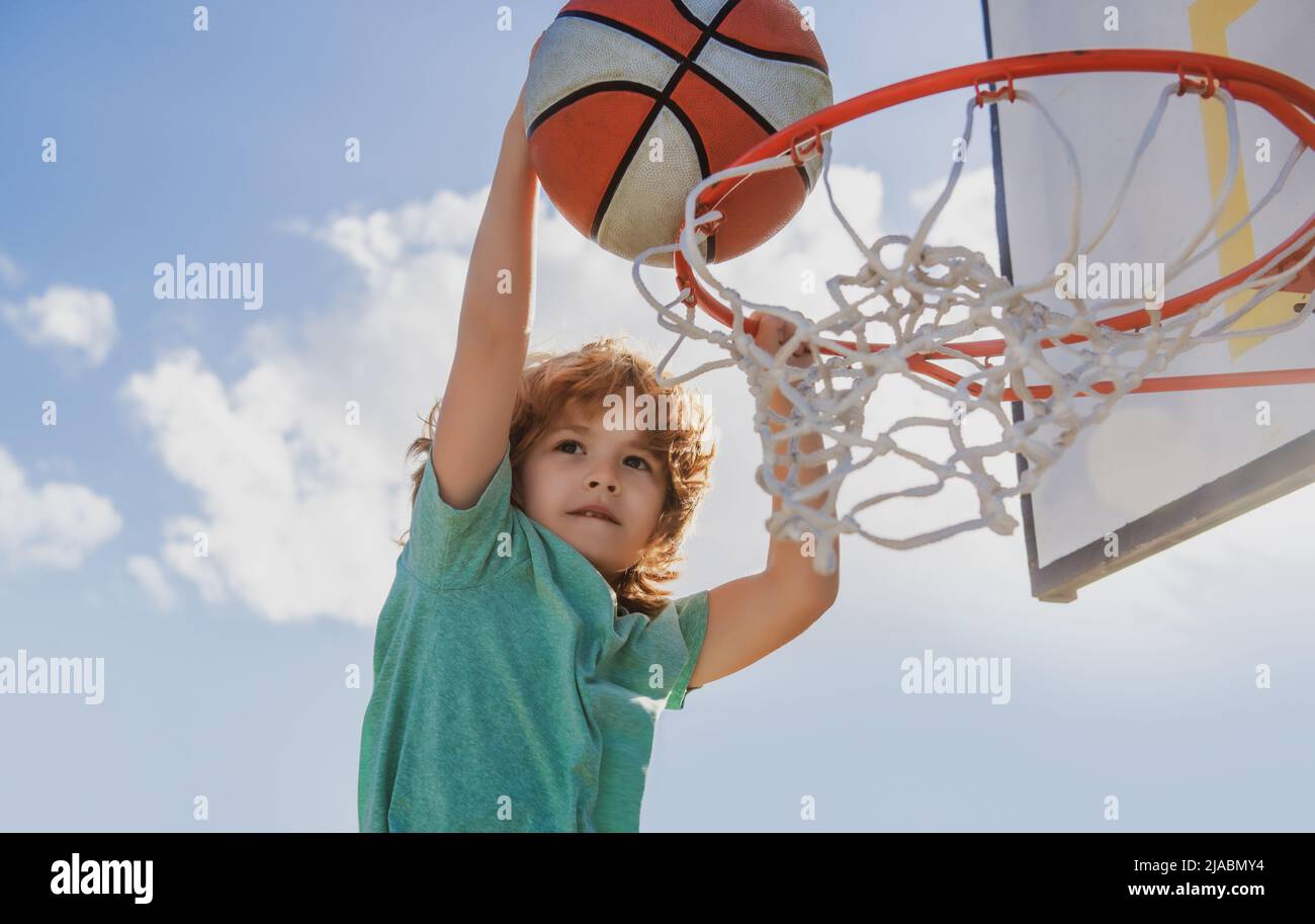 Basketball kid player dunking the ball. Child basketball player making