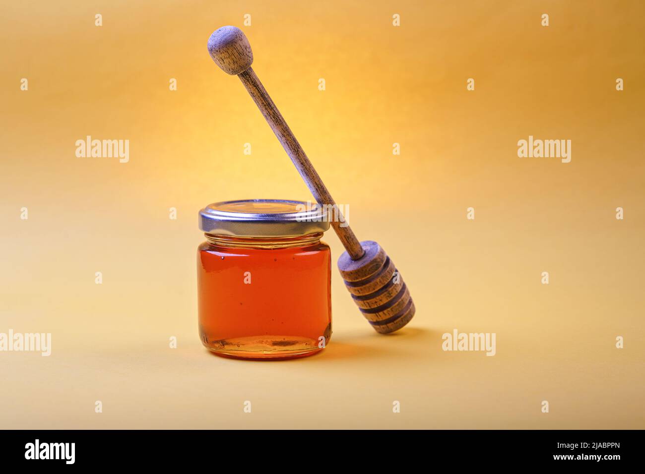 Honey background. Sweet honey in the comb, glass jar and a spoon for