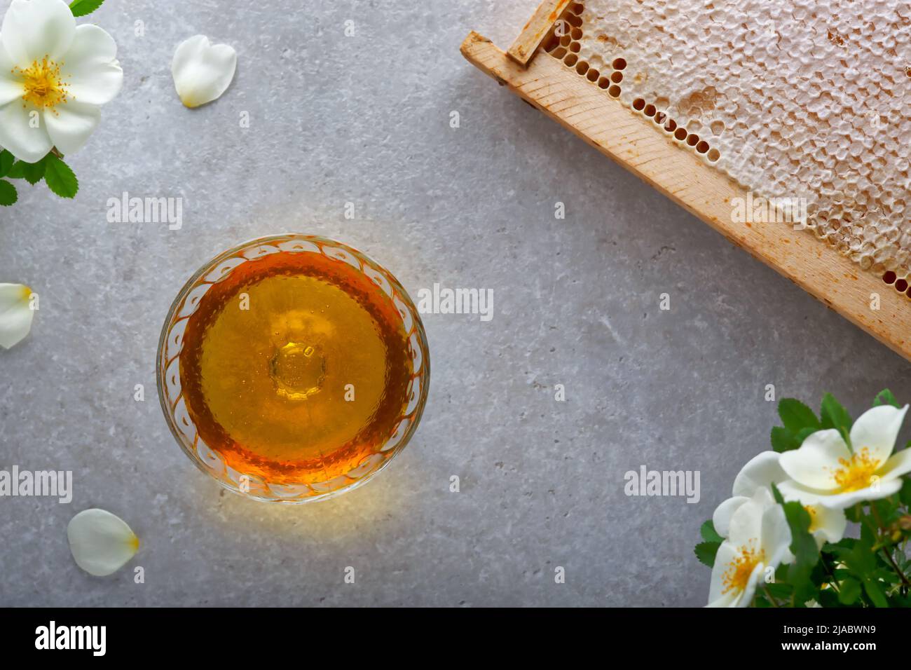 Honey background. Sweet honey in the glass jar, honey comb on the table ...