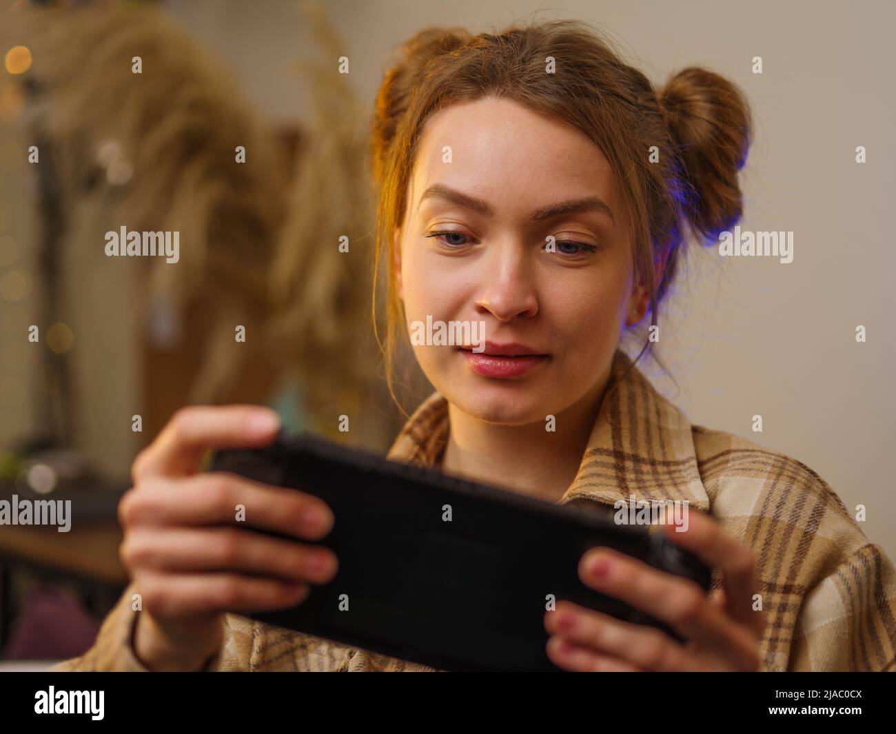 Beautiful girl gamer with a portable game console in her hands. Close