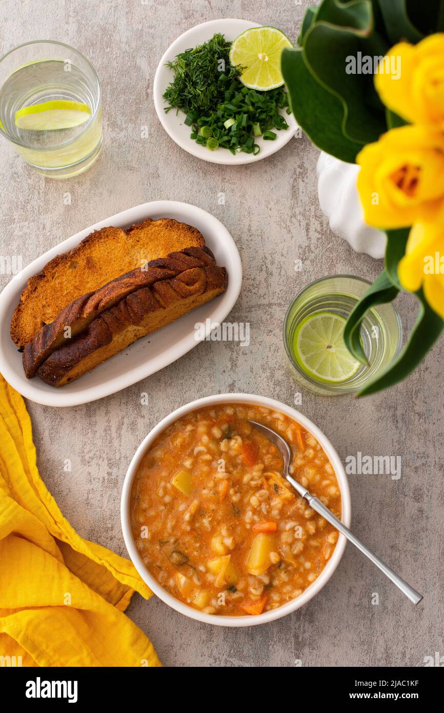 Soup with barley and sauerkraut, a plate with soup and croutons, top