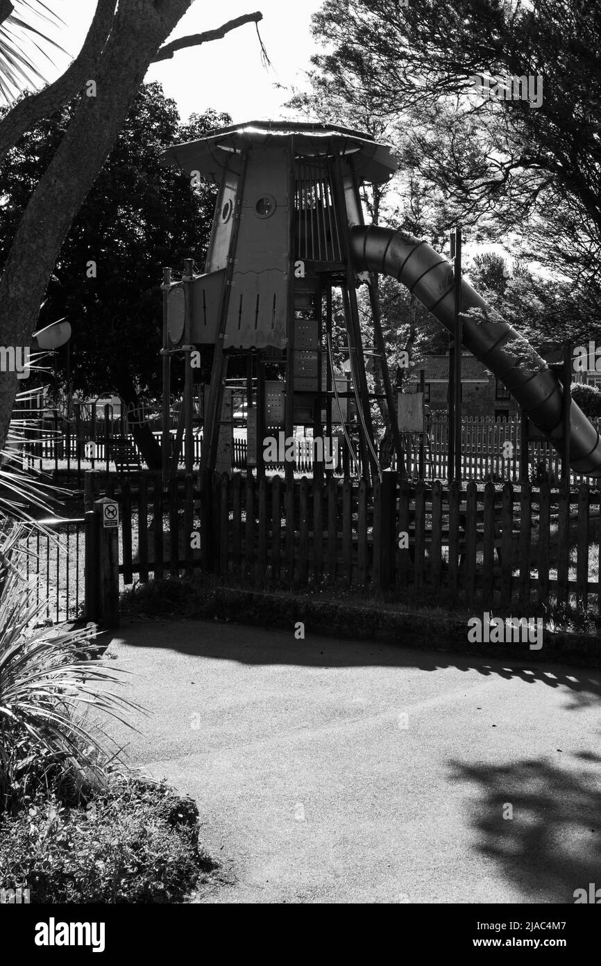 A tall children's slide with an enclosed tree house structure at the top Stock Photo