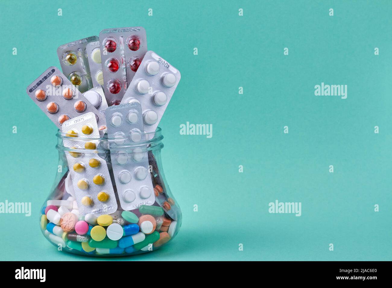 Pills Container Glass Glass container with medical pills on color background and copy space ...