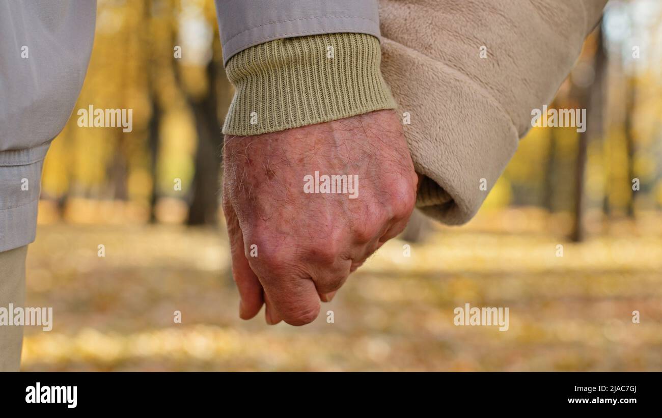 Close up two wrinkled hands elderly couple hold arms together romantic gesture old middle-aged family grandparents mature partners support marriage Stock Photo
