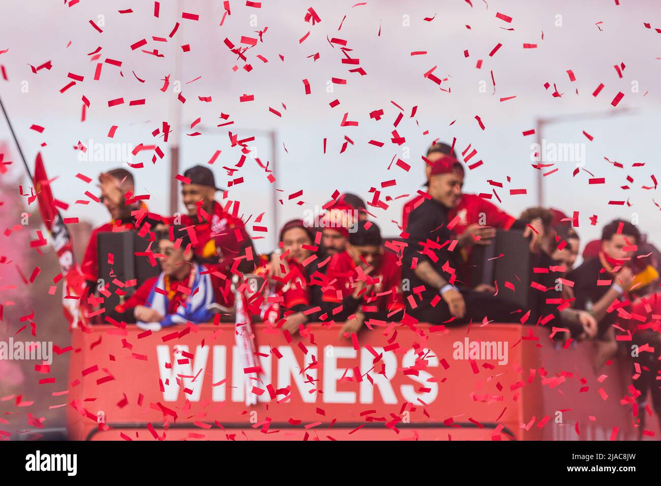 Red ticker tape in front of the Liverpool Football Club open top bus