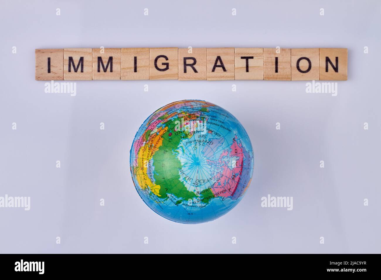 Word immigration written on wooden cubes and world globe. Top view. Stock Photo