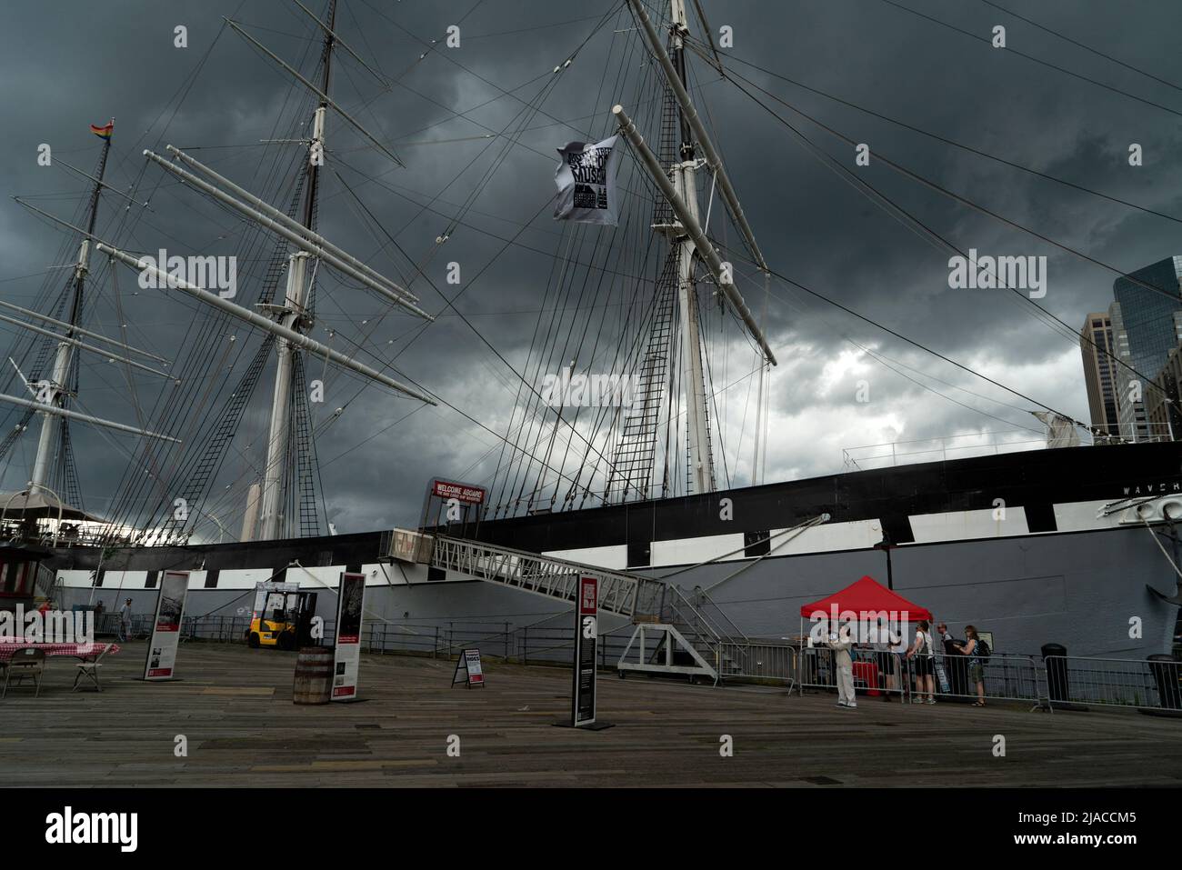 The South Street Seaport Museum's 1885 cargo ship Wavertree berthed on Pier 16 in the South Street Seaport with an impending thunderstorm. Stock Photo