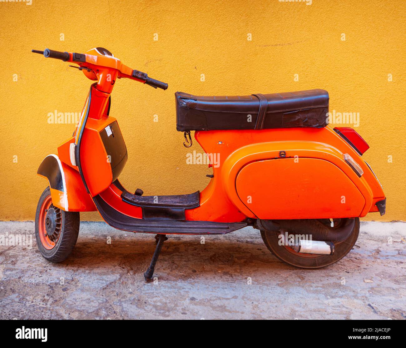 Orange Vespa, famous italian motorcycle parked in the street of Linosa Stock Photo