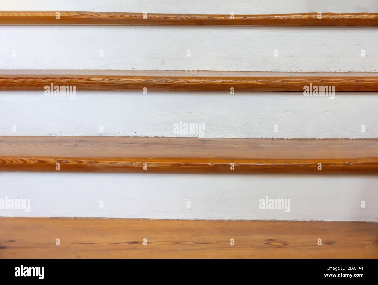 Vintage wooden stair with brown plank tread and white riser. Interior stairway old structure