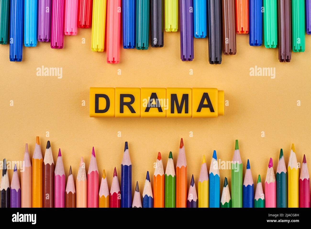 Alphabet letters in word drama on color background with pencils. Flat lay. Stock Photo