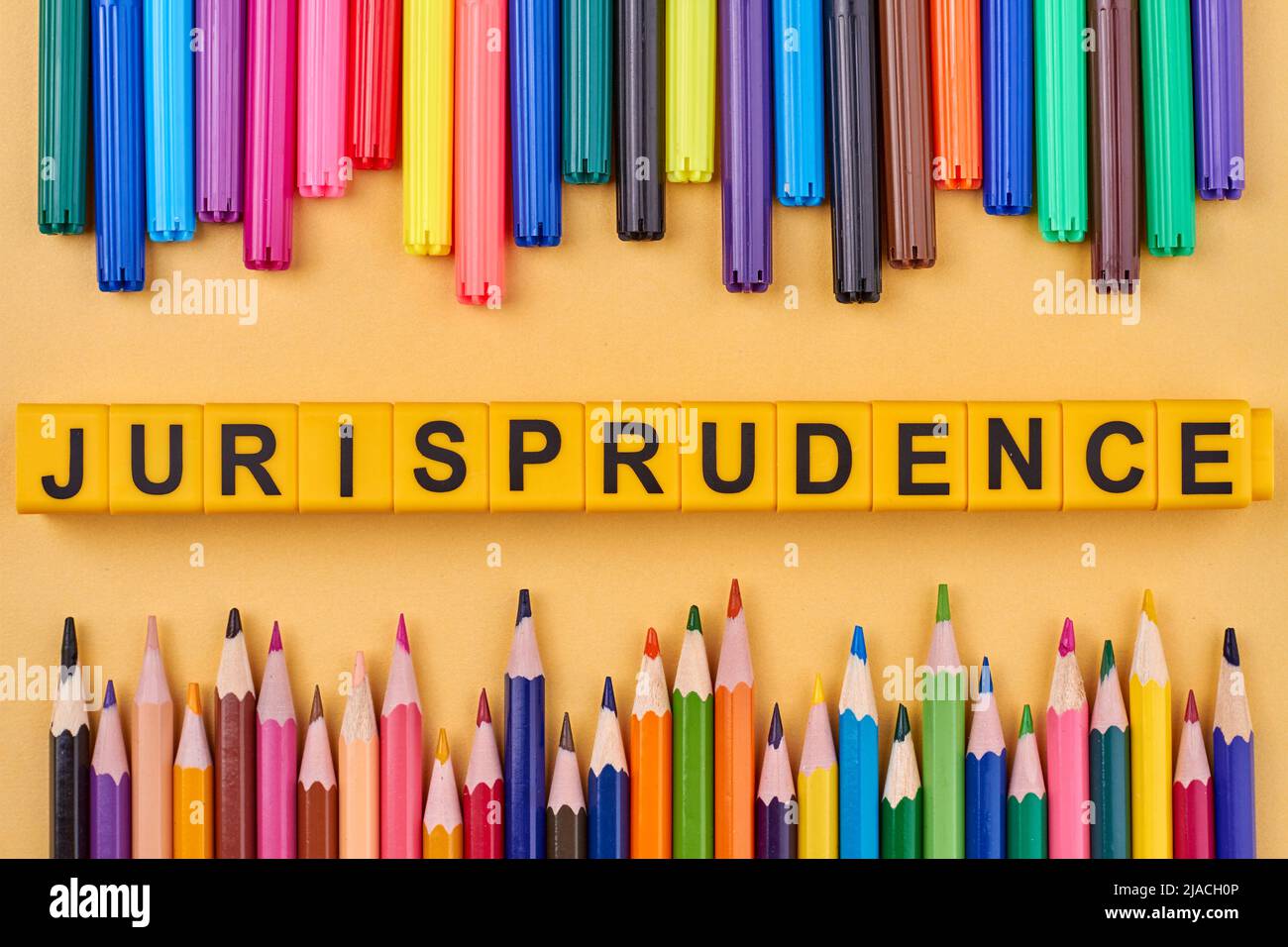Jurisprudence inscription made from colorful cubes on yellow background. Flat lay composition from colorful pencils. Stock Photo
