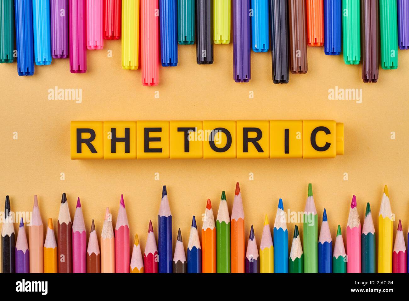 Flat lay composition with colorful pencils and word rhetoric written on yellow cubes. Education concept. Stock Photo