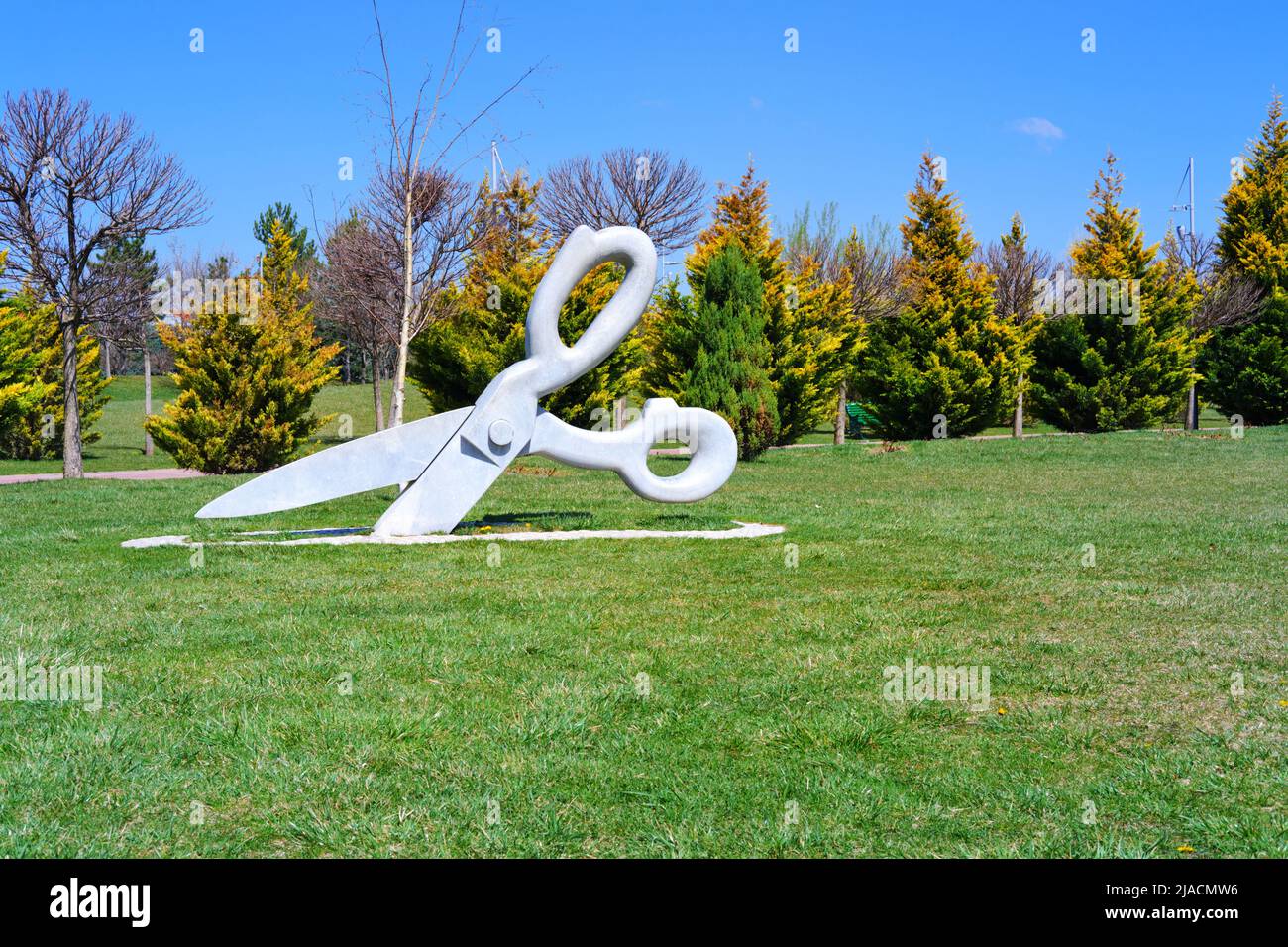 Statue of huge Scissor on the grass at park in a sunny summer day with