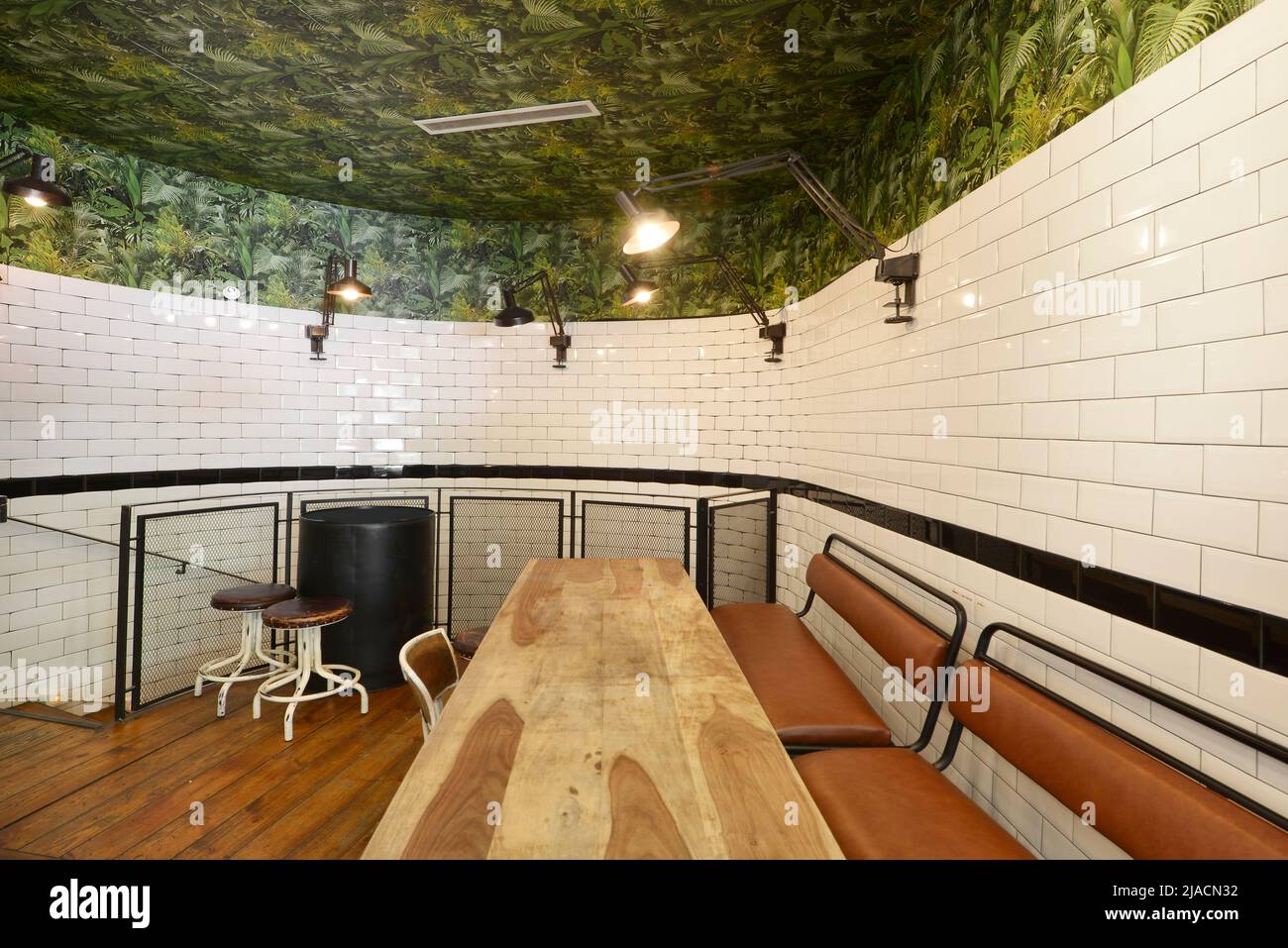 curved living room with unvarnished wooden dining table with stools and