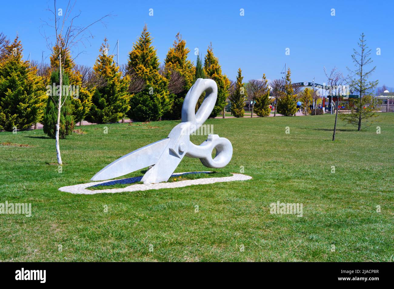 Statue of huge Scissor on the grass at park in a sunny summer day with