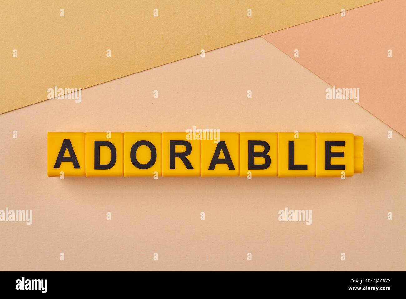 Adorable word written on alphabet blocks on light background close up