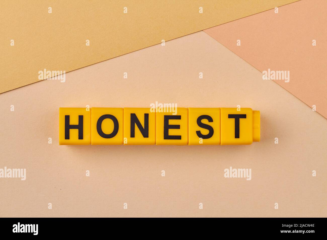 The word honest written on yellow cubes close up. Free of deceit. Truthful and sincere. Stock Photo