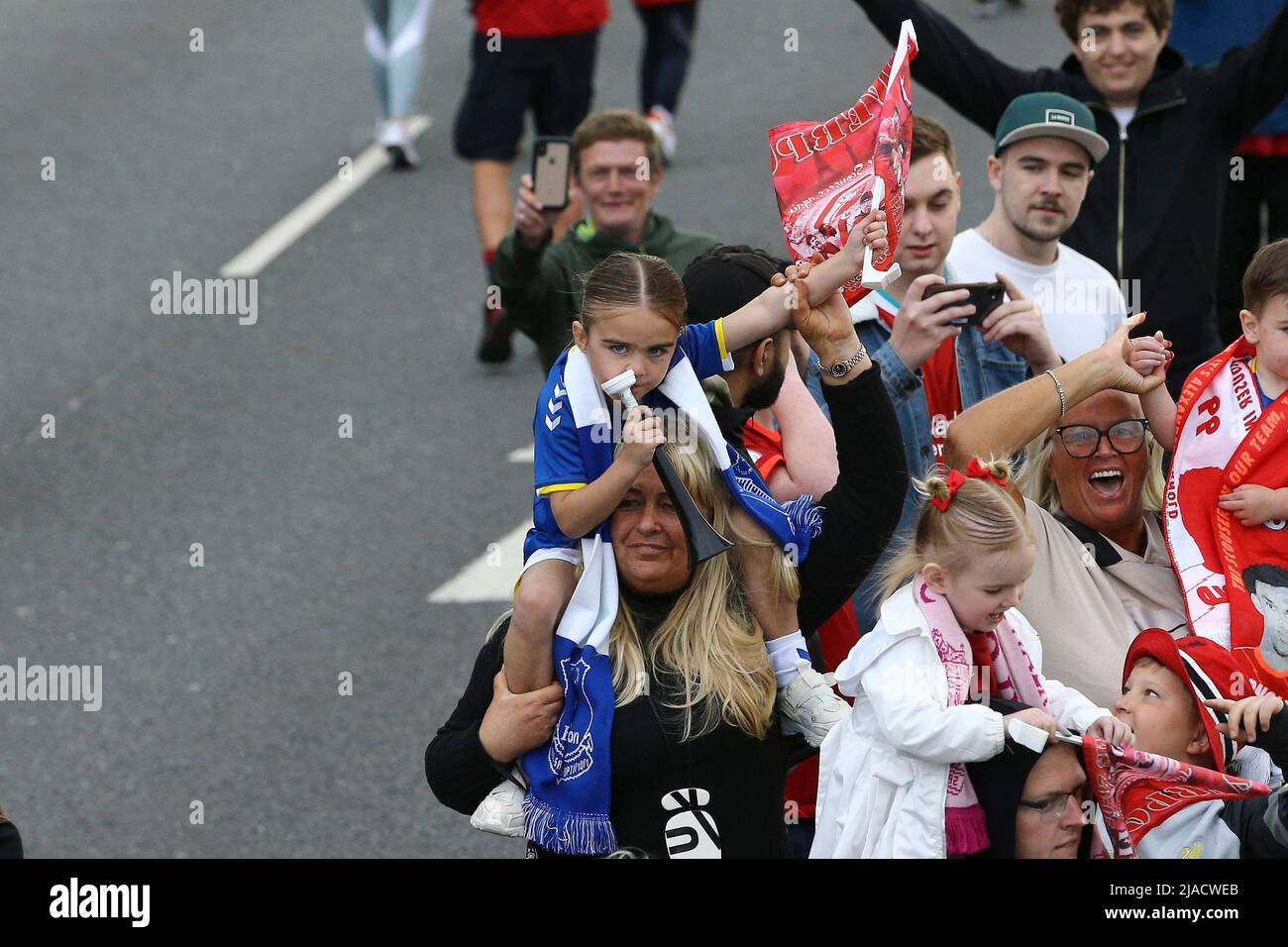 Liverpool, UK. 29th May, 2022. A little girl in an Everton is persuaded to wave a Liverpool flag by her Mum. Liverpool Football Club victory parade in Liverpool on Sunday 29th May 2022. Liverpool FC celebrate this season's mens and women's teams achievements with an open top bus parade around Liverpool. Editorial use only. pic by Chris Stading/Andrew Orchard sports photography/Alamy Live news Credit: Andrew Orchard sports photography/Alamy Live News Stock Photo