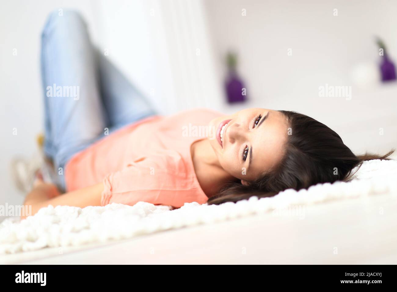 Relaxed woman lying on the floor indoors and smiling Stock Photo - Alamy