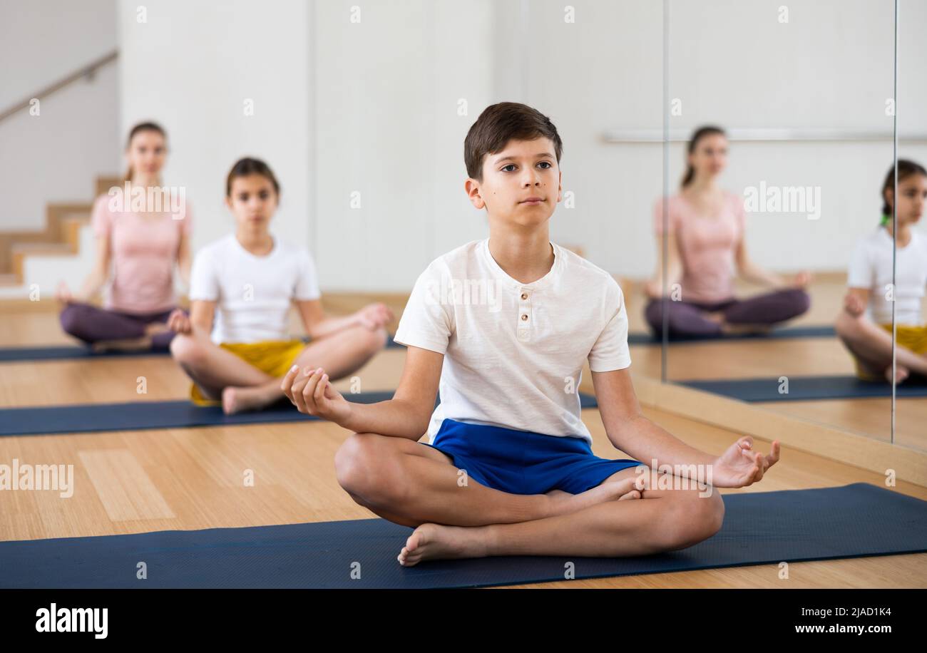 Boy practicing lotus pose during family yoga training Stock Photo - Alamy