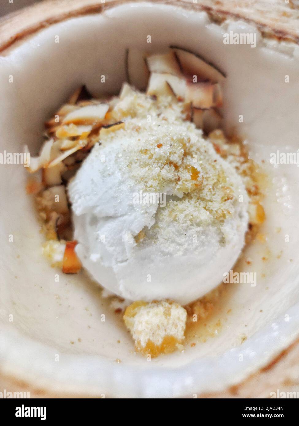 Overhead view of a bowl of coconut ice cream with coconut shavings in a coconut shell Stock Photo