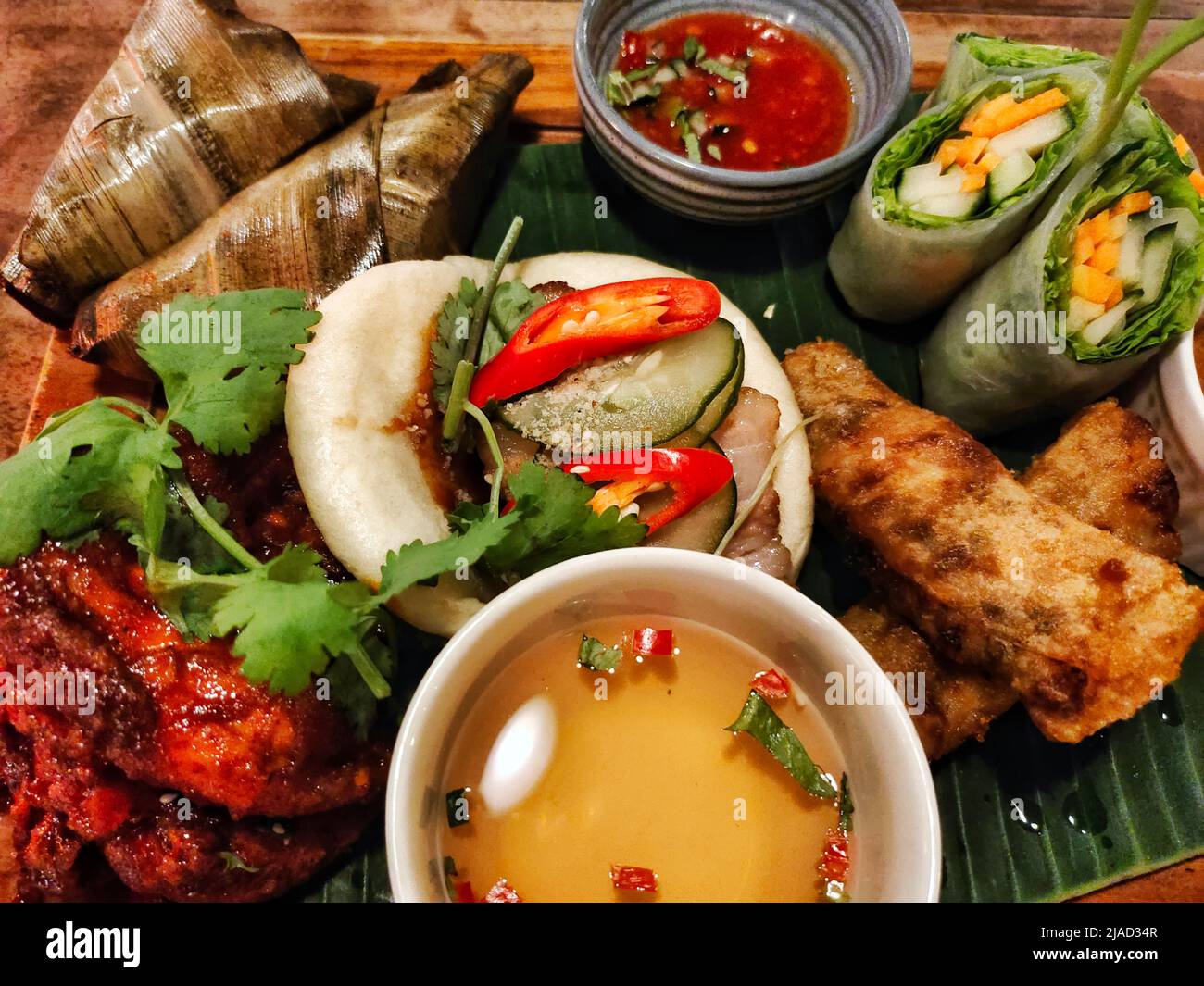 Overhead view of spring rolls, Summer rolls, rice parcels, pork bao bunds and chili sauce Stock Photo