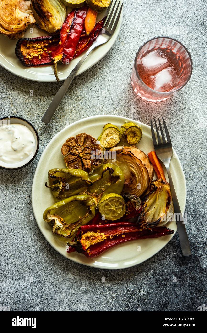 Overhead view of a plate of roasted peppers, garlic and sour cream