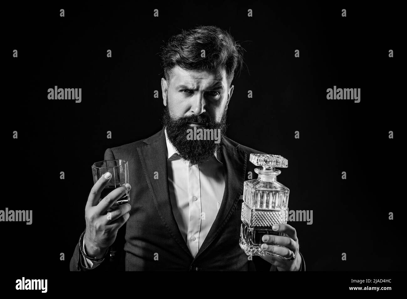 Luxury beverage concept. Sipping whiskey. Man Bartender holding glass of whisky. Bearded handsome man holding glass of whiskey. Stock Photo