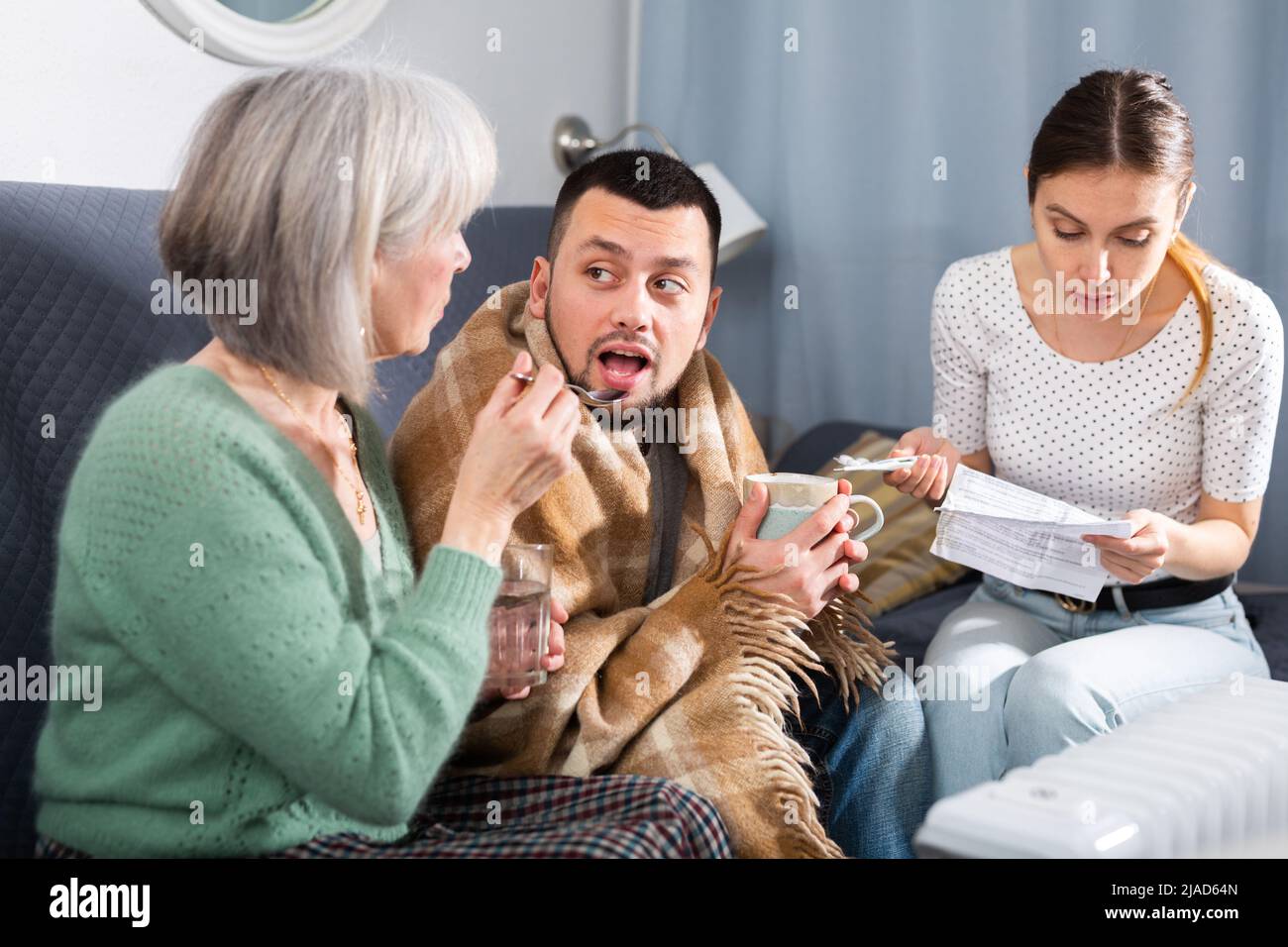 Women giving treatment to sick man in apartment Stock Photo Alamy