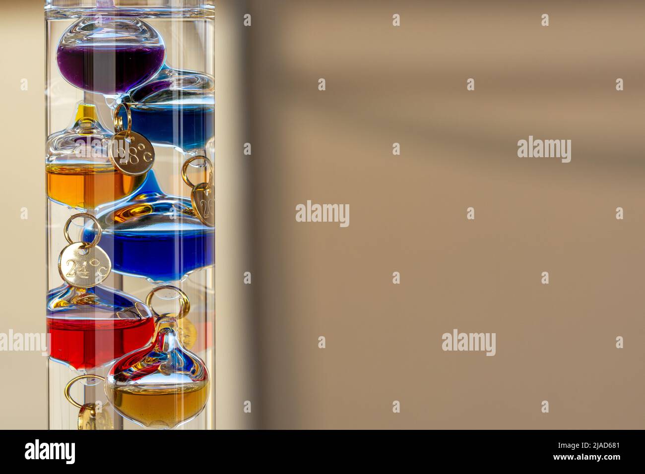 Galileo thermometer with bright colors and reflections in different backgrounds Stock Photo