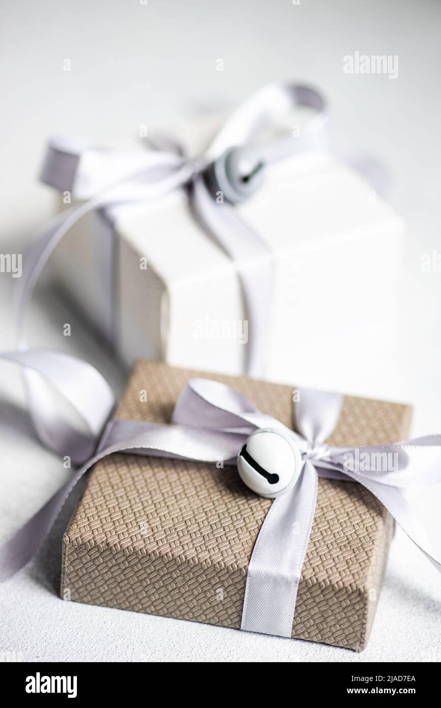 Two gift boxes on a table wrapped with ribbons and bells Stock Photo