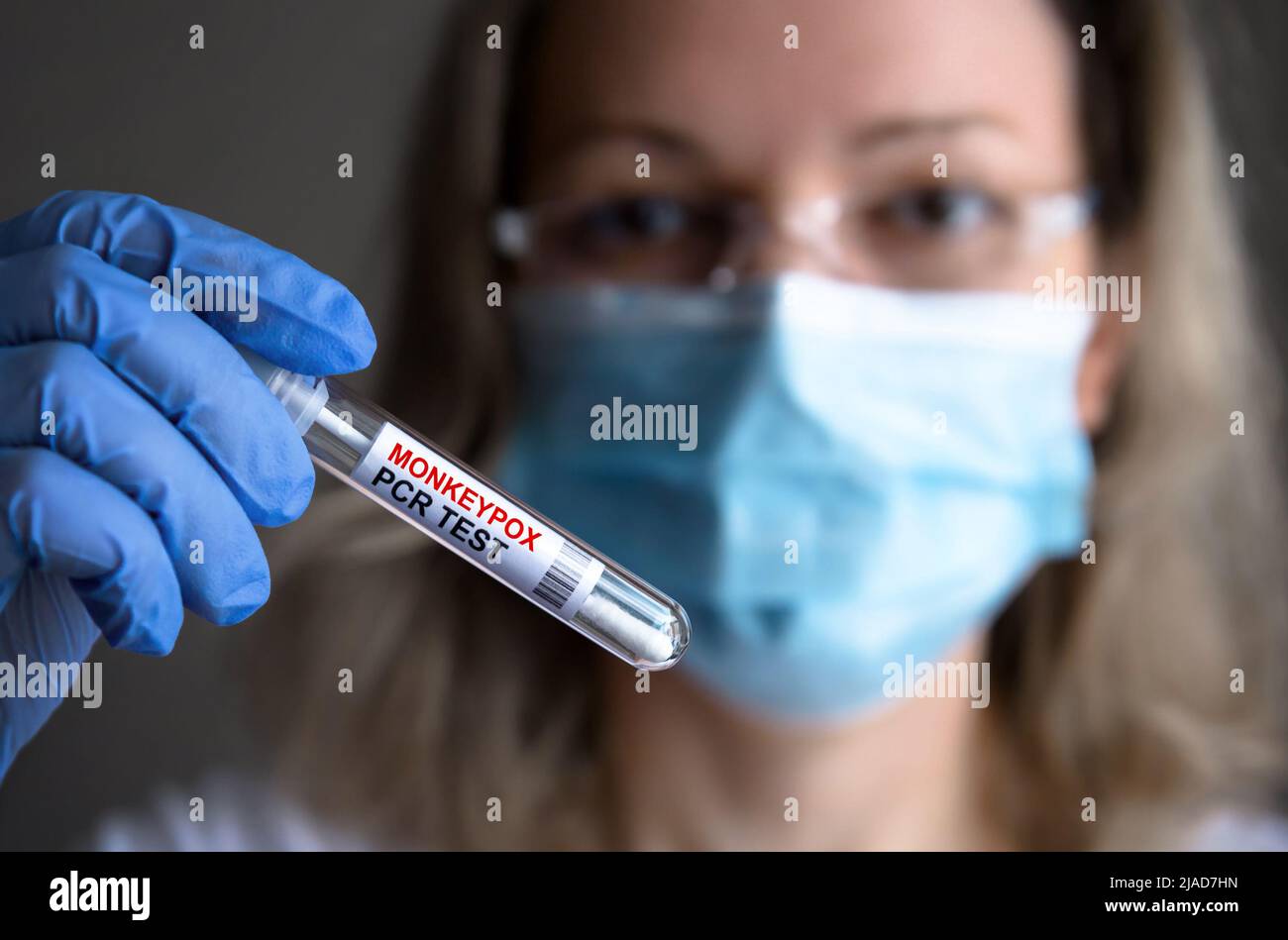 Monkeypox PCR test tube in doctors hand, medical worker in medical mask shows swab collection kit for smallpox virus diagnosis and monkey pox research Stock Photo