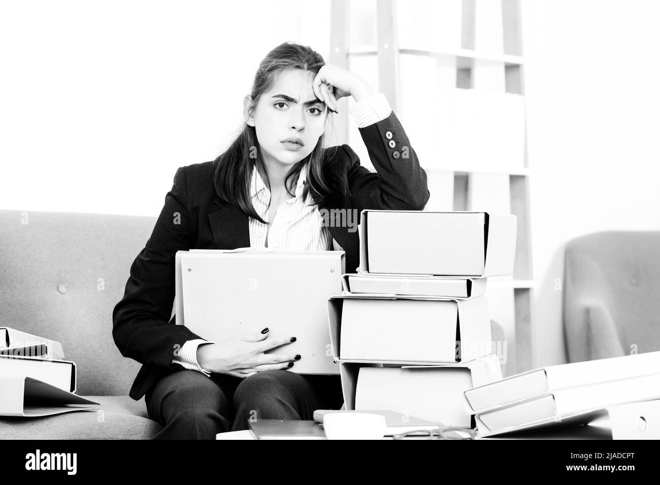 Sadness depressed businesswoman with many folders of documents ...