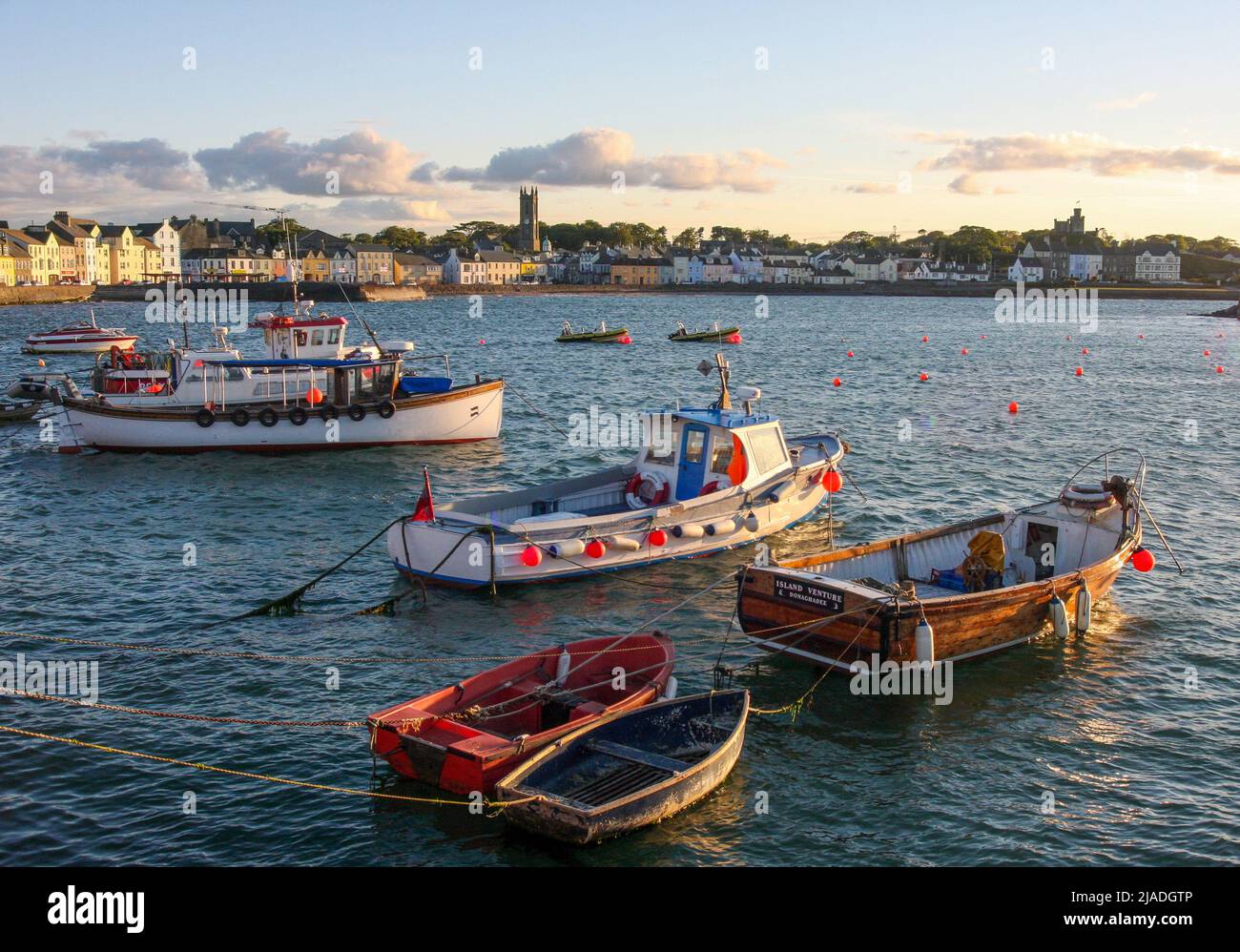 Summer evening sun on seafront promenade and boats moored in harbour on County Down coast - seaside town Donaghadee, Northern Ireland. Stock Photo
