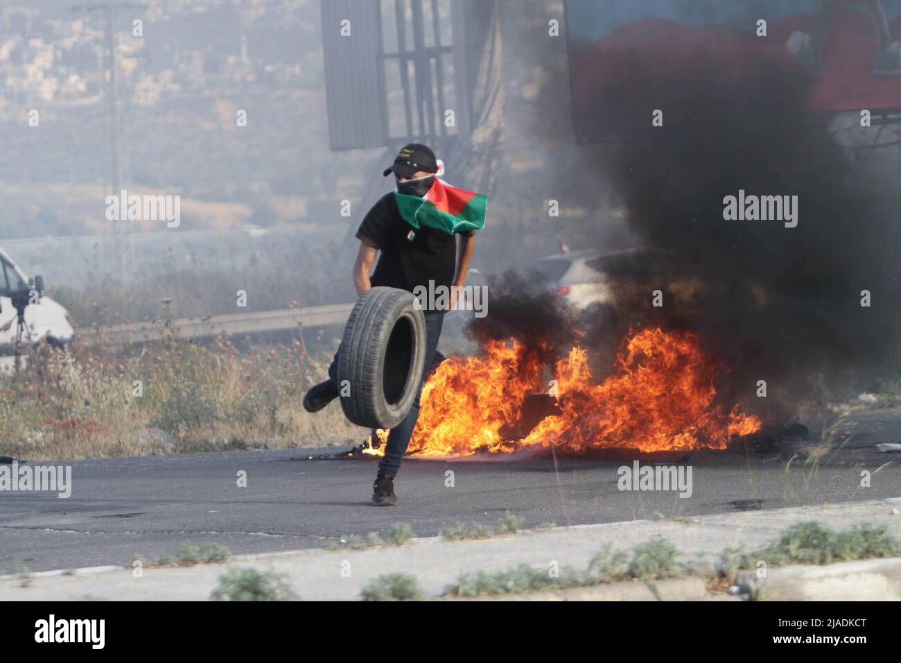 Nablus, West Bank, Palestine. 27th May, 2022. Palestinian protesters burn tires during a demonstration against the intrusion of Jewish settlers into the Al-Aqsa Mosque and the organization of the march of Israeli flags inside its walls, near the Hawara military checkpoint under Israeli control, south of the city of Nablus in the occupied West Bank. (Credit Image: © Nasser Ishtayeh/SOPA Images via ZUMA Press Wire) Stock Photo