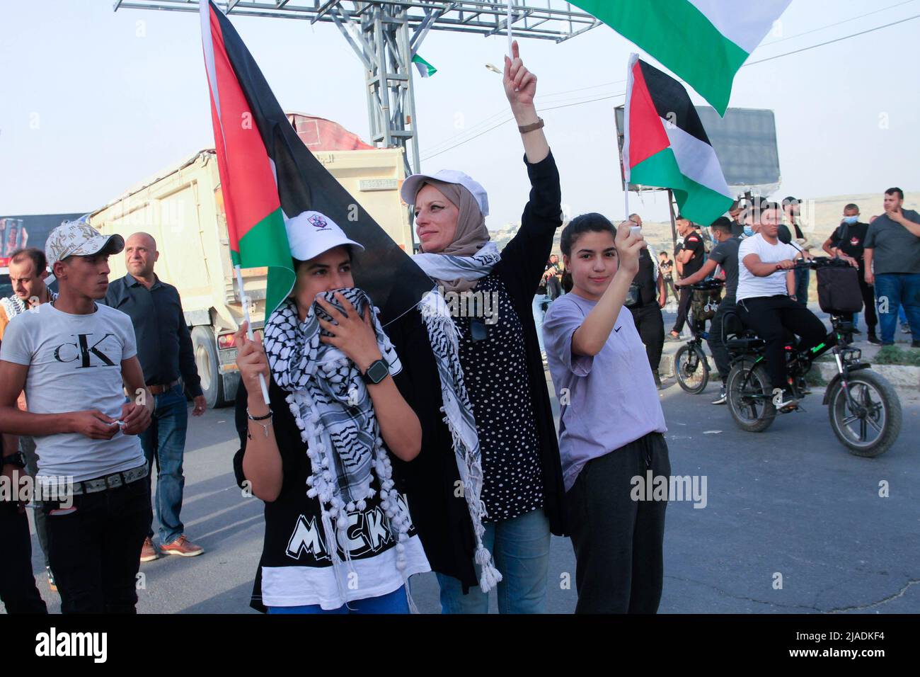 Nablus, West Bank, Palestine. 27th May, 2022. Palestinian protesters hold flags during a demonstration against the intrusion of Jewish settlers into the Al-Aqsa Mosque and the organization of the march of Israeli flags inside its walls, near the Hawara military checkpoint under Israeli control, south of the city of Nablus in the occupied West Bank. (Credit Image: © Nasser Ishtayeh/SOPA Images via ZUMA Press Wire) Stock Photo