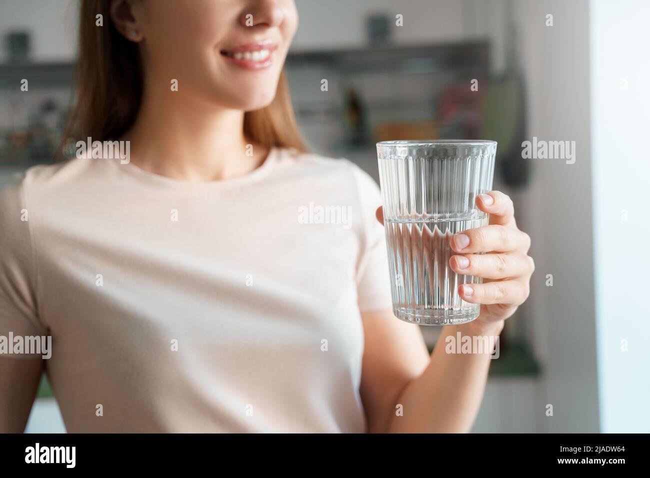 Young female hand holds glass of clear water cropped shot Stock Photo