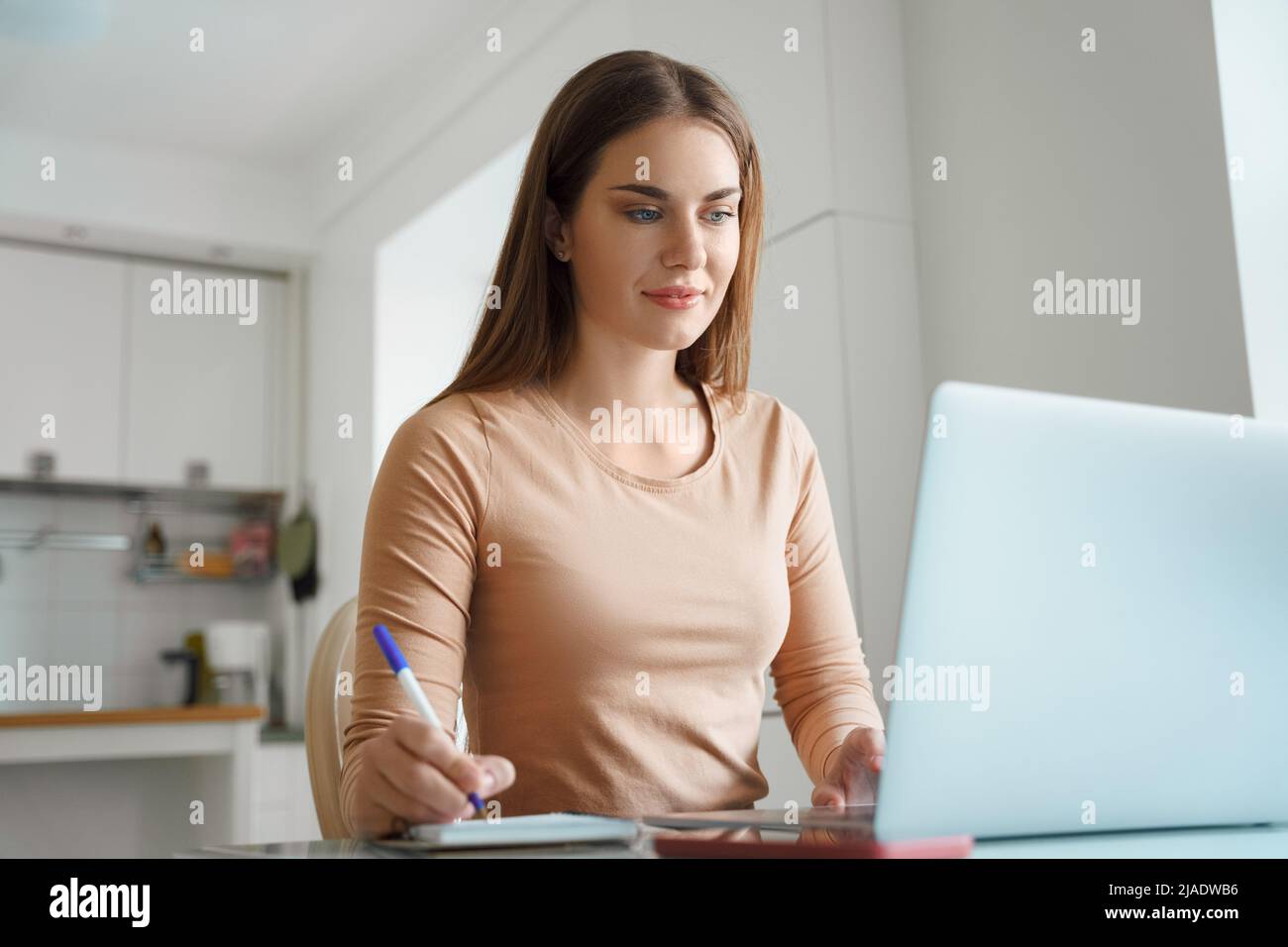 Young teenage woman watching online video tutorial on laptop Stock Photo