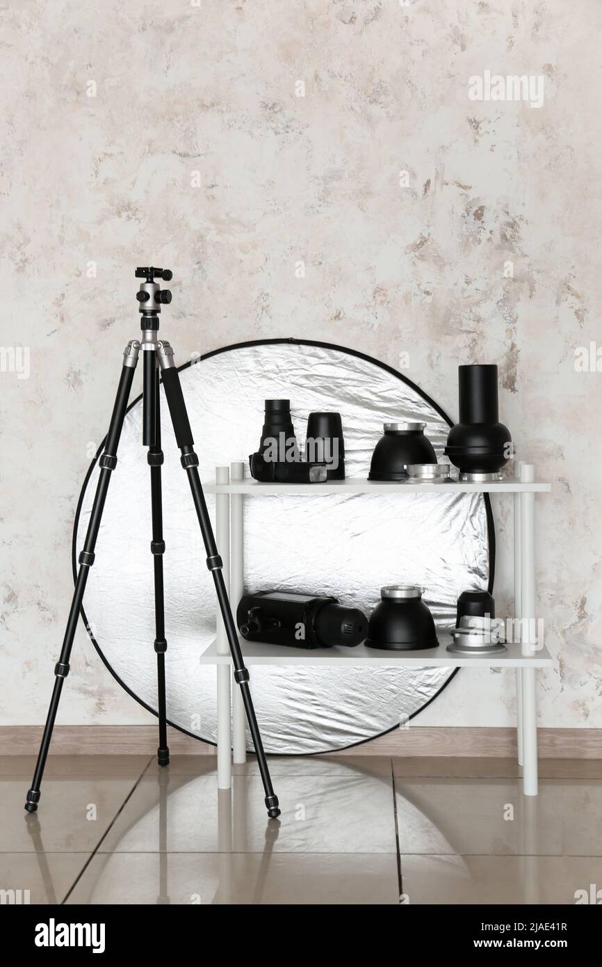 Lighting equipment, reflector and tripod in modern photo studio Stock