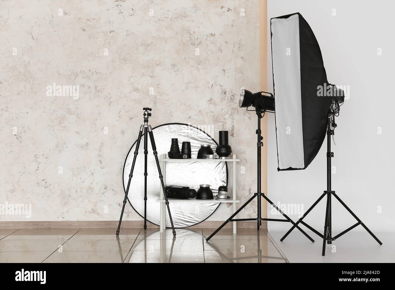 Lighting equipment, reflector and tripod in modern photo studio Stock
