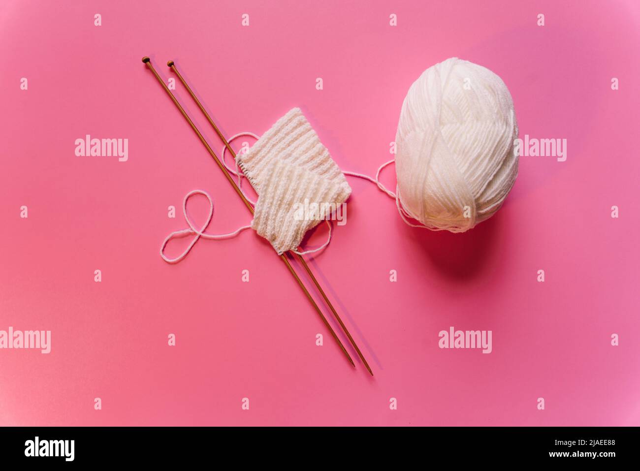 knitting needles on pink background Stock Photo