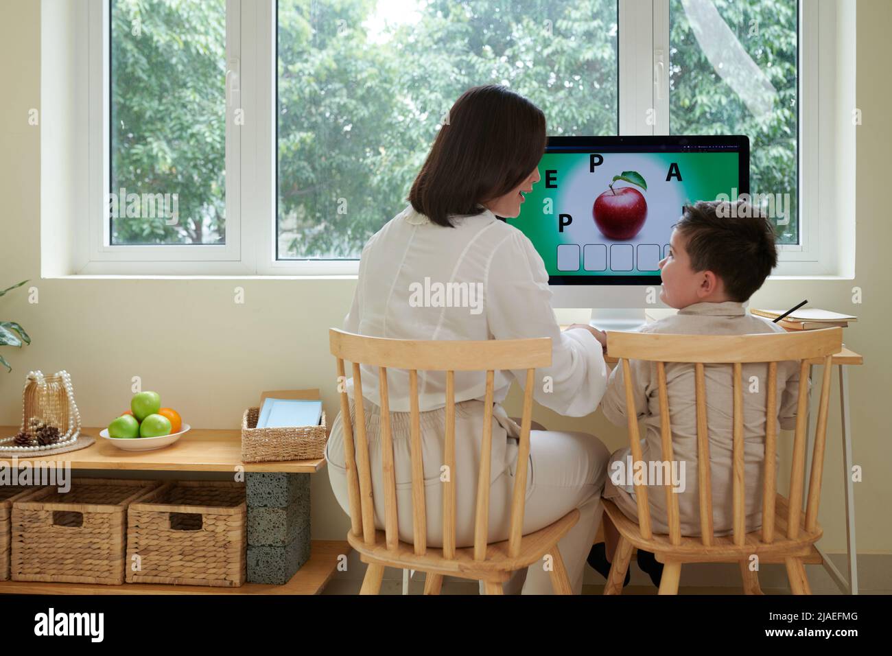 Home tutor teaching boy English language while they are sitting at
