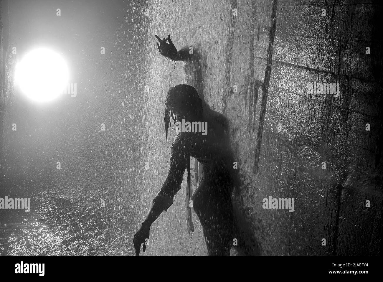 Young girl dancing streams of water in stormwater Stock Photo