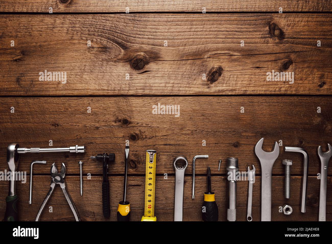 Flat lay with various work tools on wooden background working table. Top view on new hand tool set for repair, construction kit, overhead. Must-have for men. Equipment for building. Industry concept Stock Photo