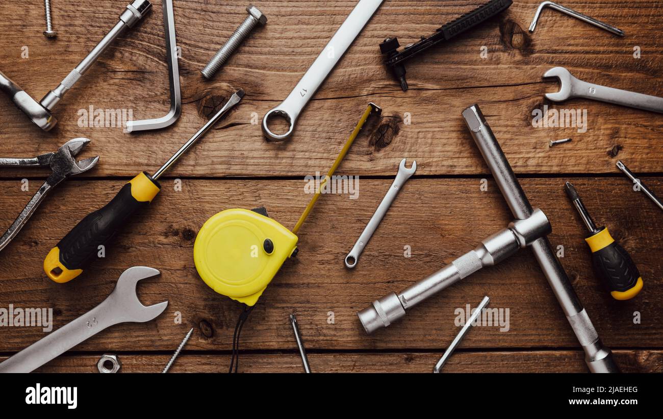 Flat lay with DYI composition of various work, carpentry tools knolled on brown wooden decks background pattern working table. Top view on new hand tool set for repair and construction kit, overhead Stock Photo