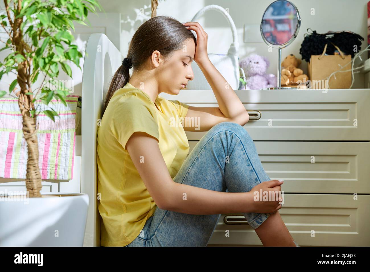 Sad teenage girl sitting on the floor at home Stock Photo - Alamy
