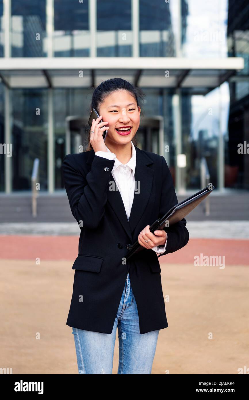 business woman talking by phone in front of office Stock Photo