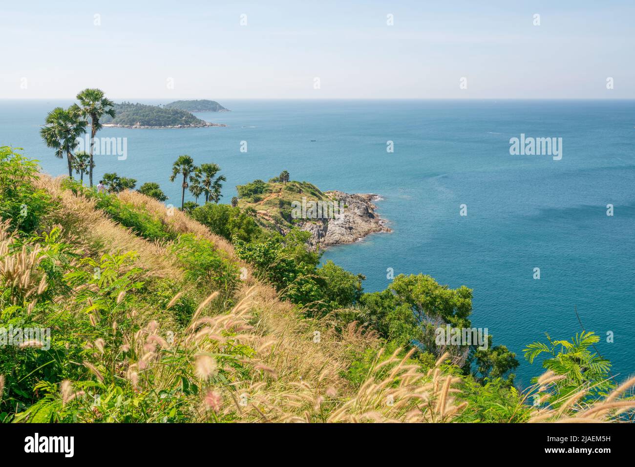Phuket island Laem promthep cape with coconut palm trees and grass in the foreground beautiful scenery andaman sea in summer season Phuket thailand Be Stock Photo