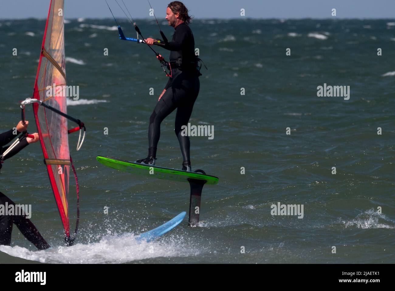Almost accident between Kite Foil Surfer and Wind Surfer, close-up Stock Photo