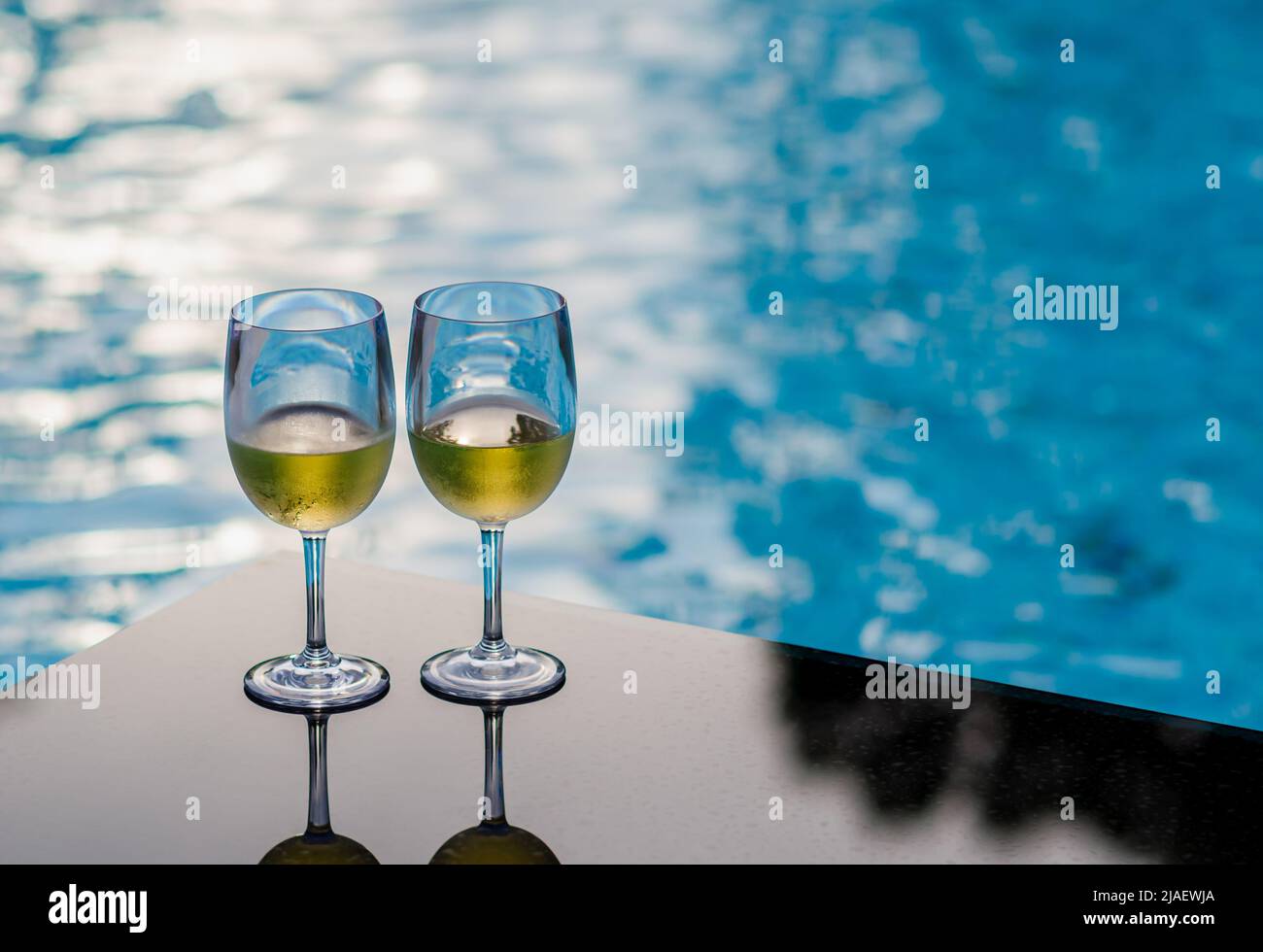 Two glasses of white wine put on table at swimming pool for Holiday and  summer drink concept Stock Photo - Alamy